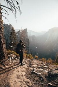 Man in woods looking out at the mountains