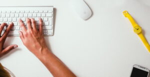 Hands typing on a computer