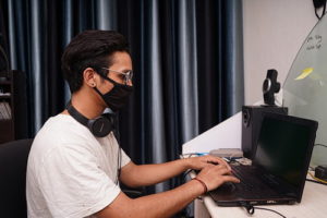 Man working on computer wearing a mask