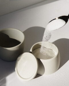 Spoon spilling sugar onto a cup