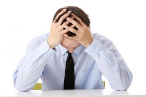 Man displaying frustration in front of a desk