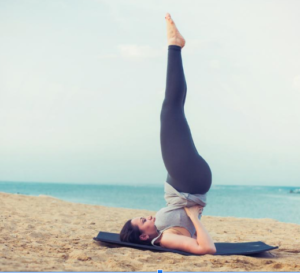 Woman on beach doing yoga