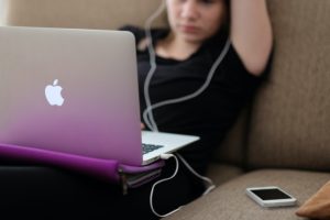 Young girl on couch working on computer