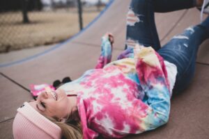 Woman with tie-dye shirt on ground