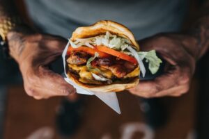 Man holding hamburger in bun